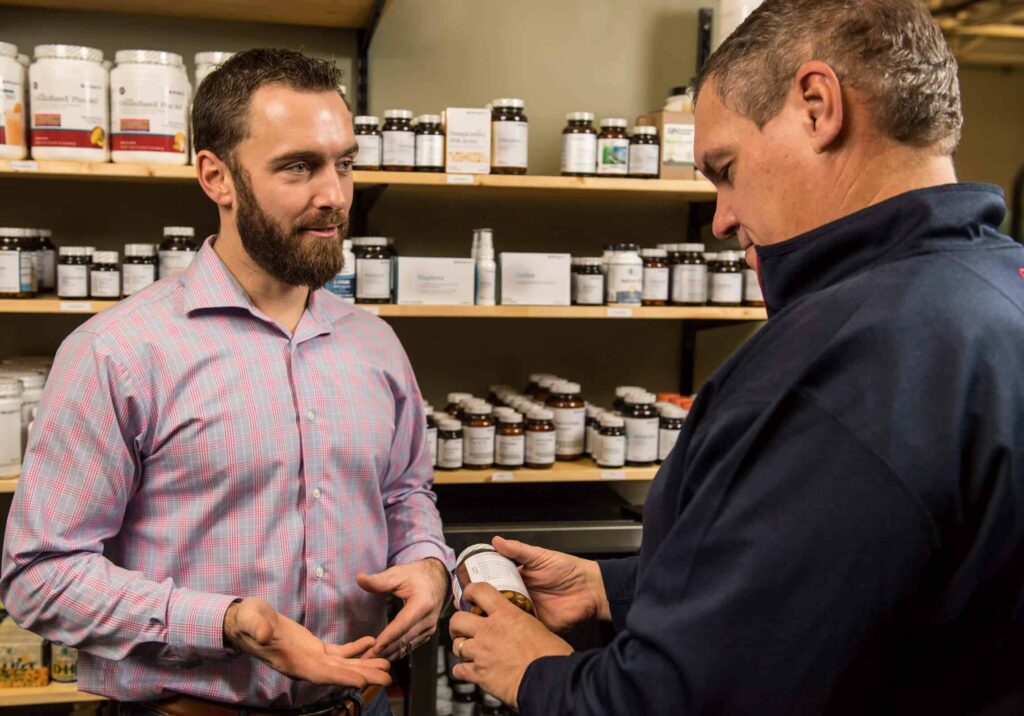 Dr. Erik Hansel explaining nutritional supplements to a patient in Active Edge Columbus Ohio