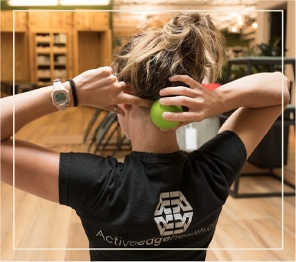 an Active Edge specialist demonstrating how to release neck tension with a tennis ball