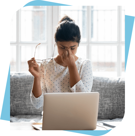 Woman with a migraine headache sitting at her computer in Columbus